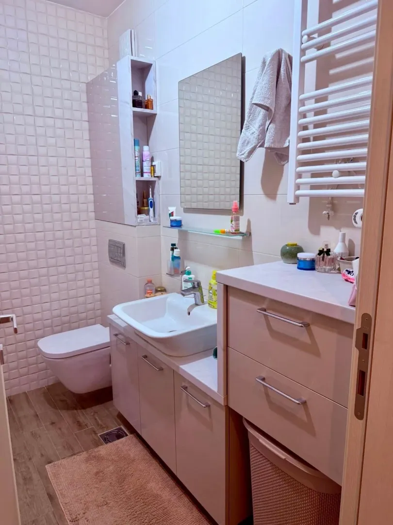 Modernly equipped bathroom with a washbasin, mirror, and toilet.