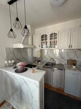 Manja svijetla kuhinja sa bijelim elementima, šankom i modernim visećim lampama. - image 8