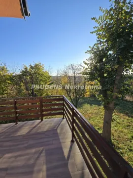 Tiled terrace with a wooden railing and a view of nature and trees. - image 12