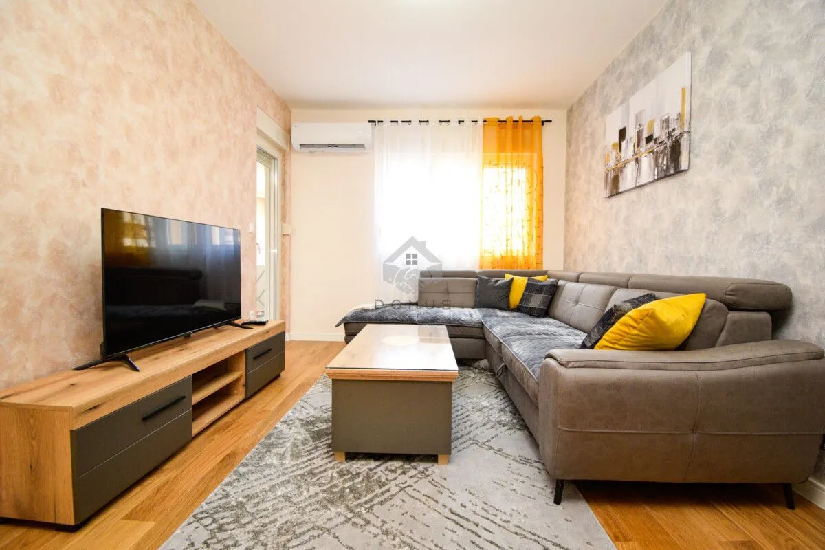 Living room with a sectional sofa, TV, and coffee table.