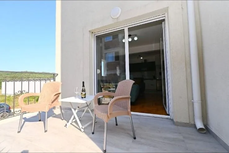 Spacious balcony with seating furniture and a view of nature.