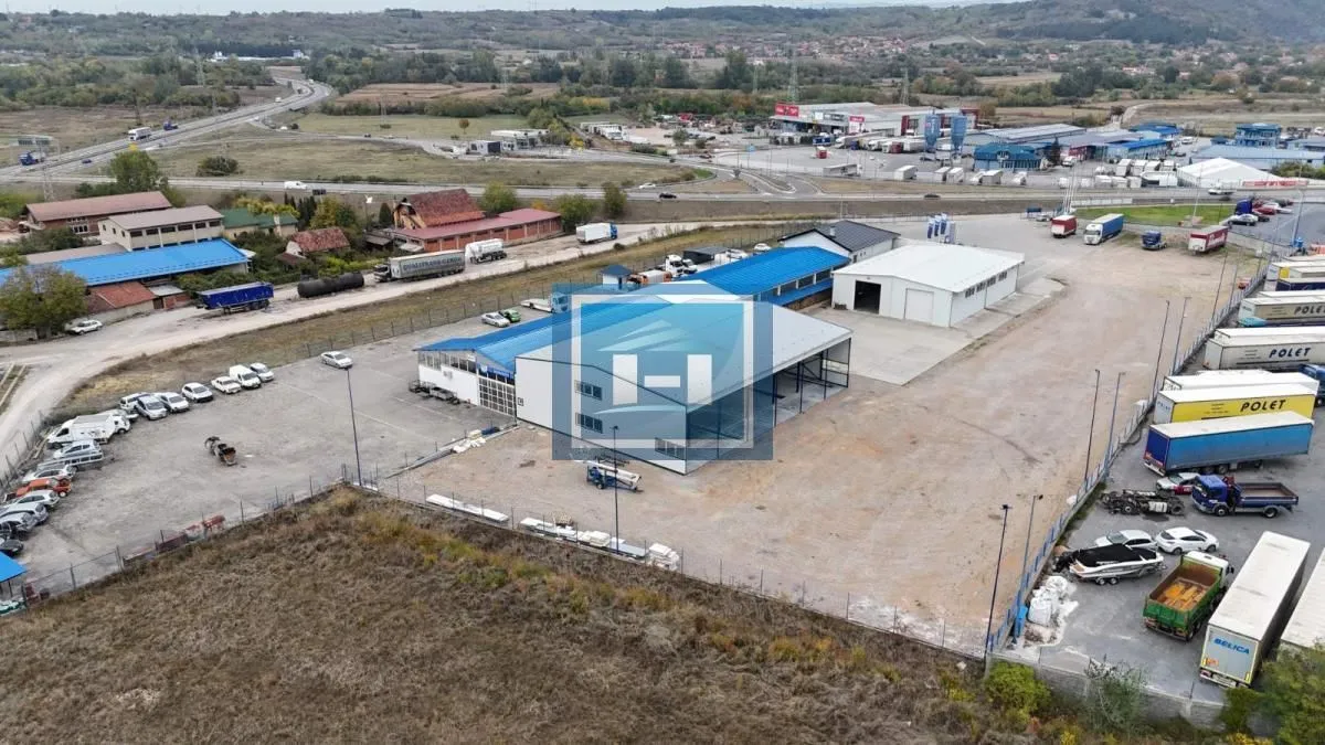 Aerial view of a commercial building with a warehouse and parking lot.