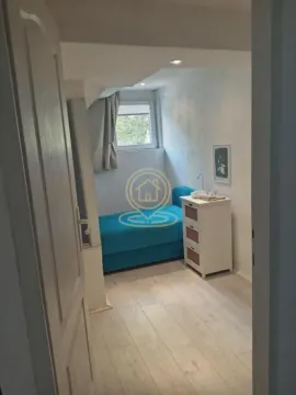 Smaller bedroom with a bed and a commode, viewed through an open door. - image 7