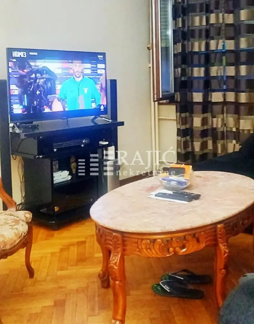 Living room with a TV and a wooden coffee table.