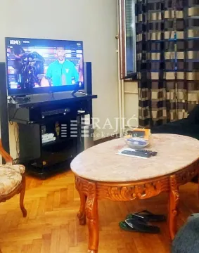 Living room with a TV and a wooden coffee table. - image 2