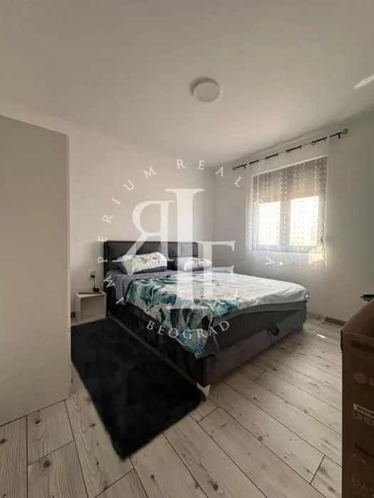 Furnished bedroom with a double bed, wardrobe, and a window.