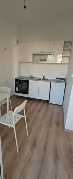 Manja bijela kuhinja sa trpezarijskim stolom i stolicama. - image 5