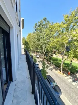 Dugačak balkon sa pogledom na ulicu i drveće. - image 9