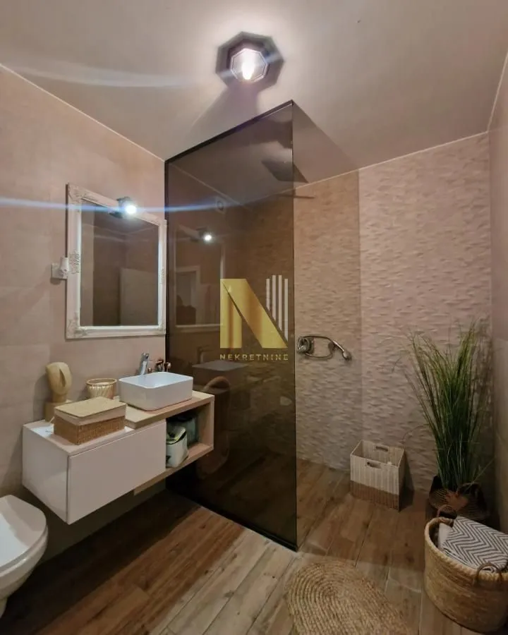 Moderno kupatilo sa tuš kabinom, umivaonikom i wc šoljom.
