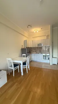 Small kitchen with a dining table and chairs in the living area. - image 6