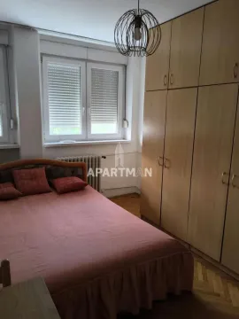 Furnished bedroom with a double bed and a large wooden wardrobe. - image 6