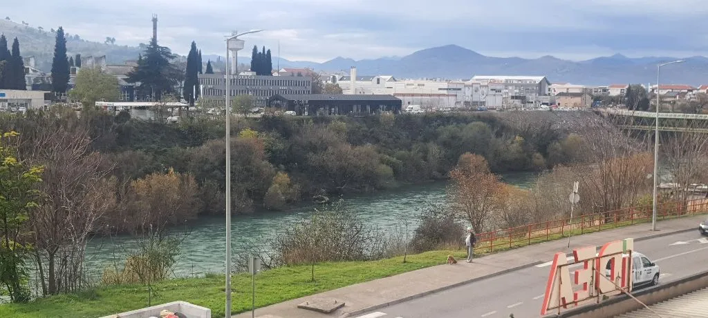 Pogled sa prozora na rijeku i gradski pejzaž.