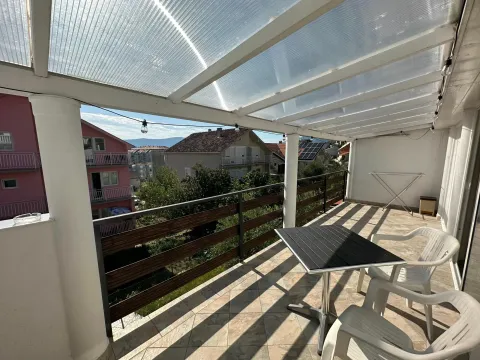 Covered terrace with a table, chairs, and a view of the neighborhood. - image 11