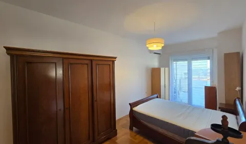 Spavaća soba sa bračnim krevetom, drvenim ormarom i izlazom na terasu. - image 3