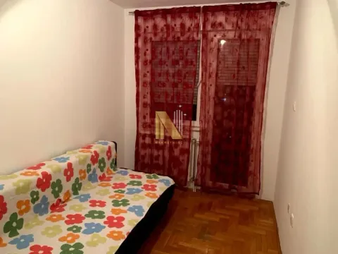 Manja soba sa kaučom i crvenim zavesama na prozoru. - image 10