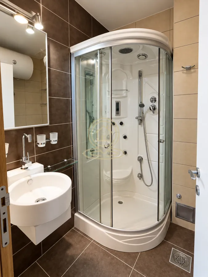 Bathroom equipped with a shower cabin, washbasin, and mirror.