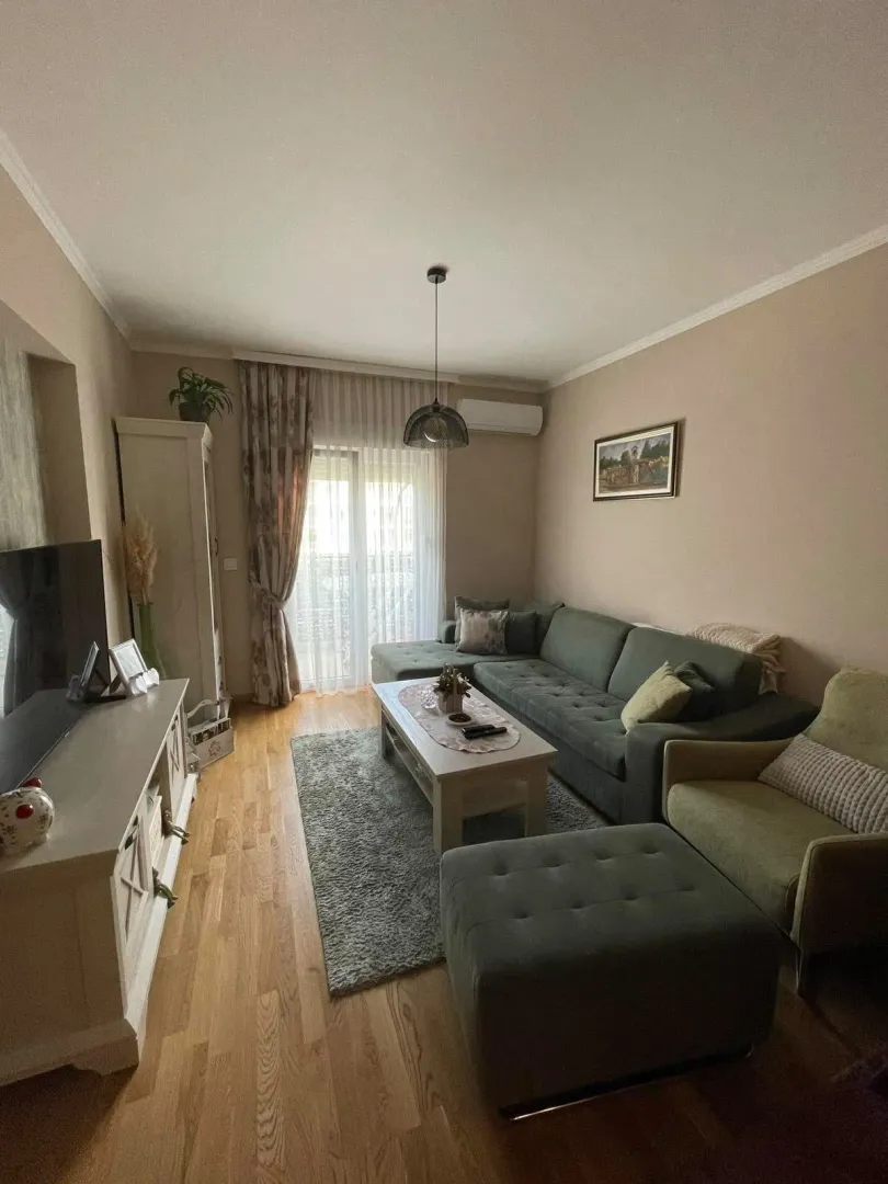 Dnevna soba sa garniturom, stočićem i televizorom.