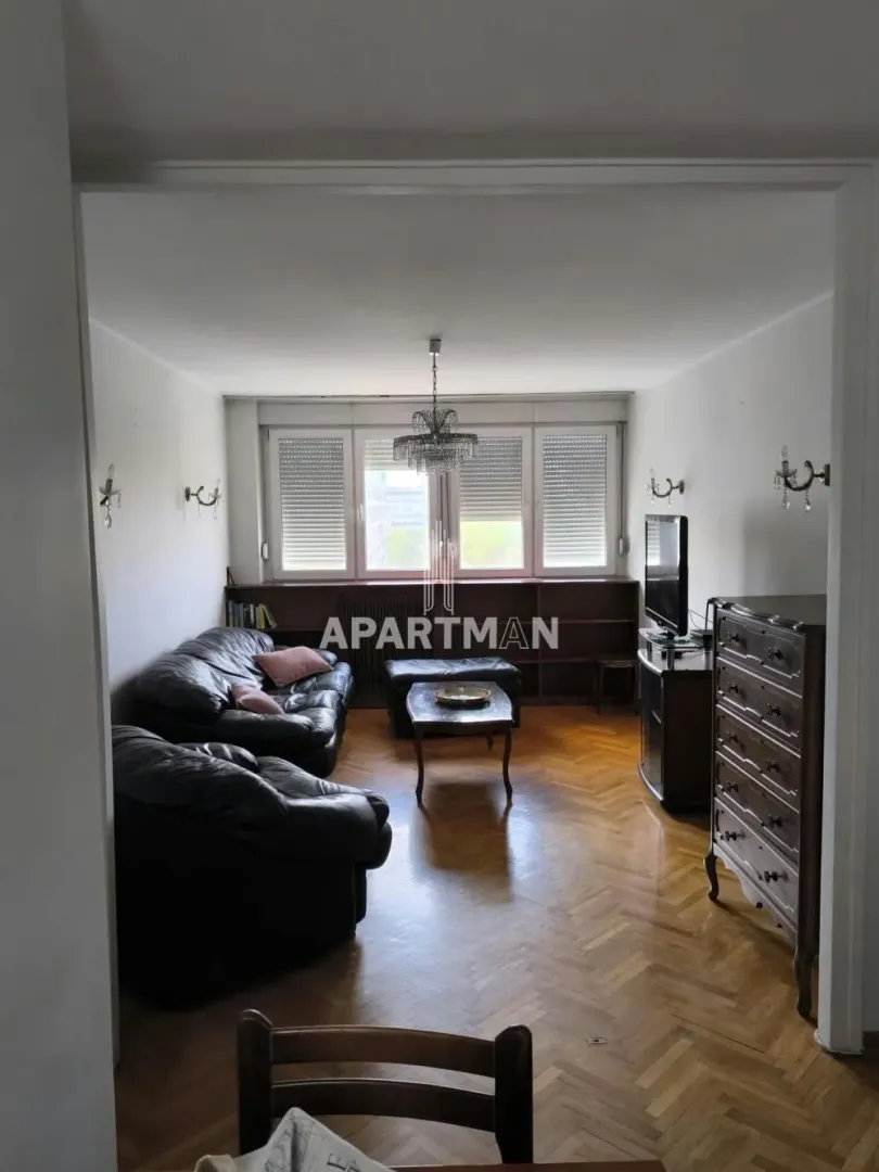 Living room with seating furniture and wooden flooring.