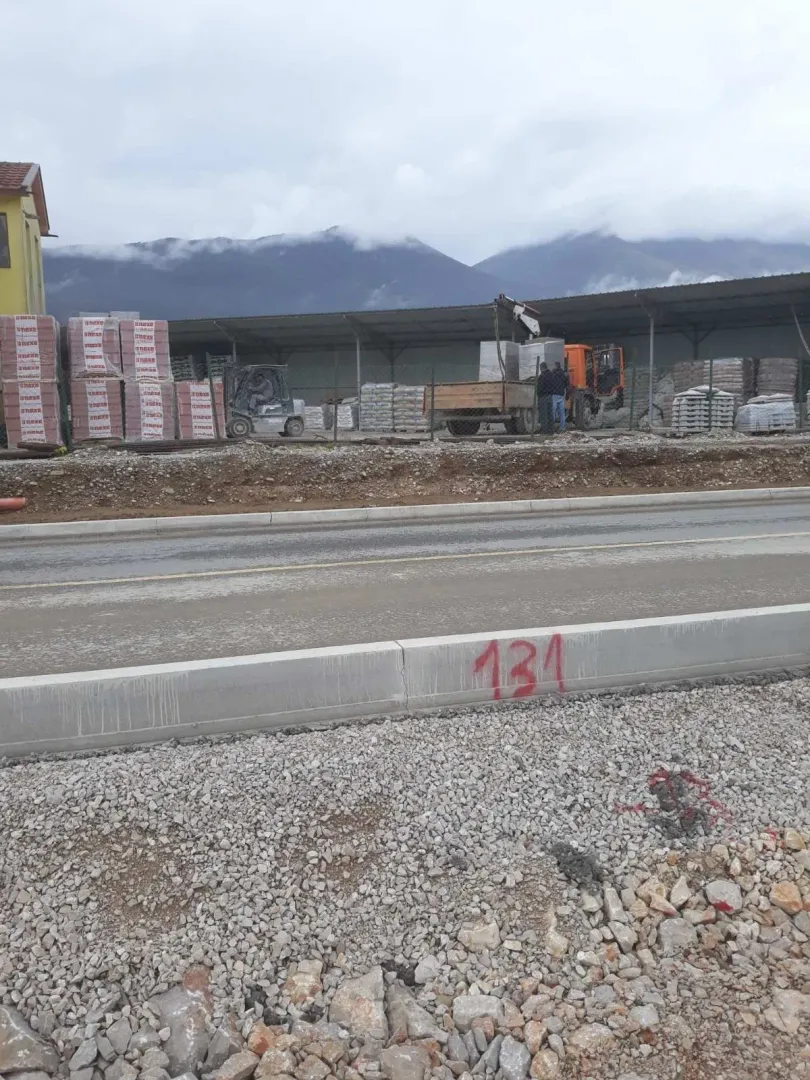 A construction plot next to a road with building materials.