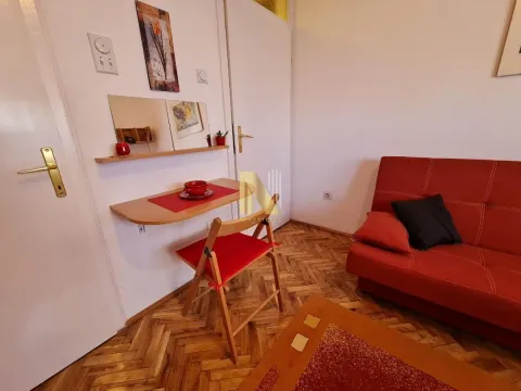 Manja dnevna soba sa crvenim kaučem i manjim trpezarijskim stolom. - image 3