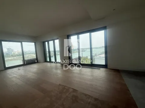 Empty room with wooden flooring and large glass surfaces overlooking the river. - image 2