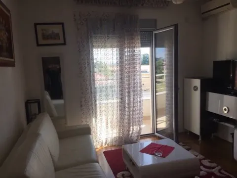 Living room with a leather sofa, coffee table, and balcony access. - image 3
