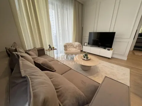 Modern living room with a comfortable sectional sofa, television, and large windows. - image 10