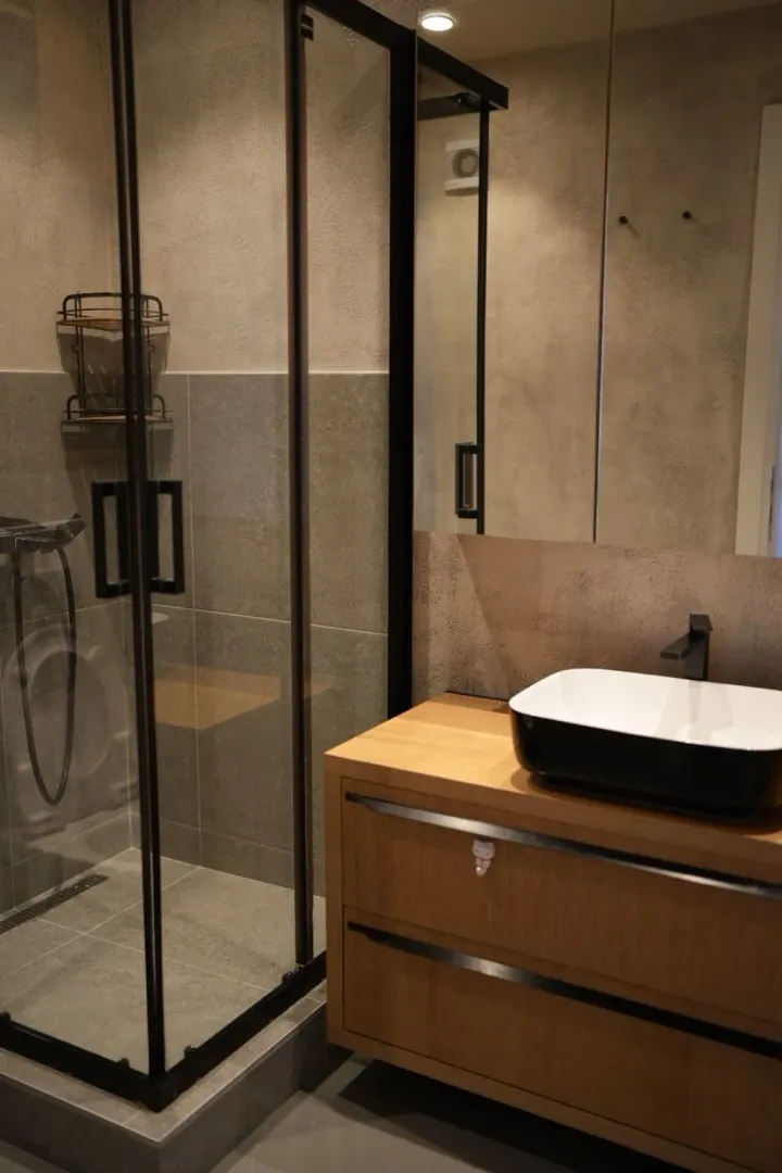 Modern bathroom with a wooden vanity and a walk-in shower.