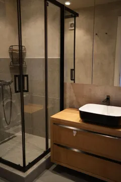 Modern bathroom with a wooden vanity and a walk-in shower. - image 8