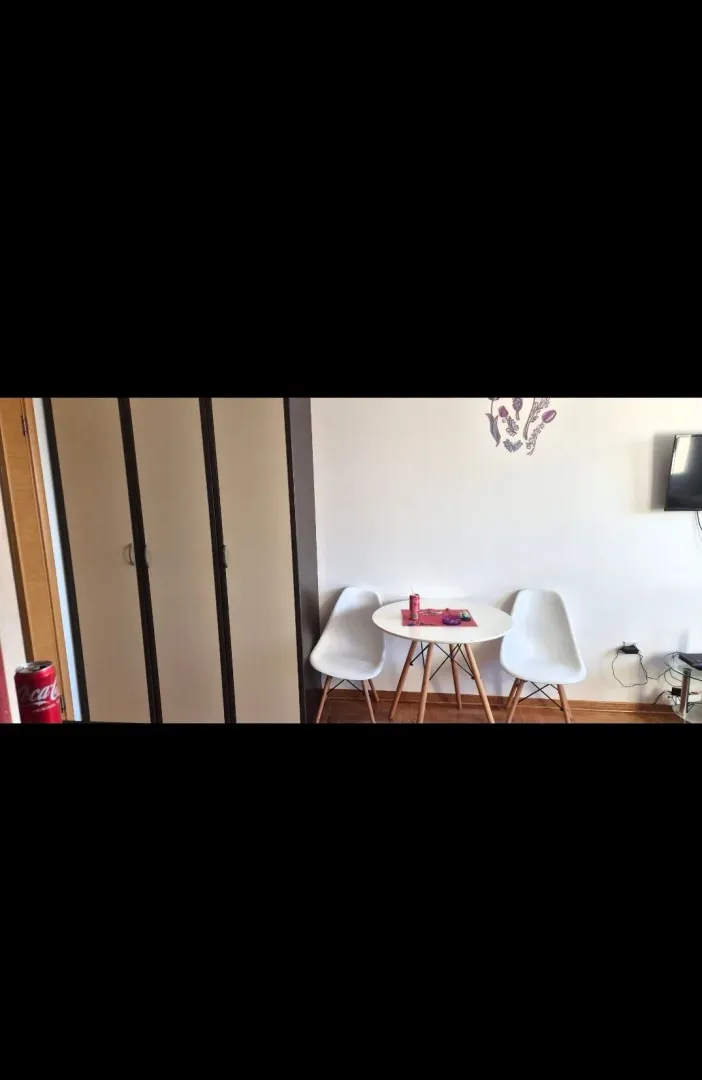 Dnevna soba sa manjim trpezarijskim stolom i ormarom.