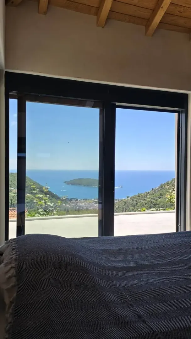 Sea and island view through a large window from the bedroom.