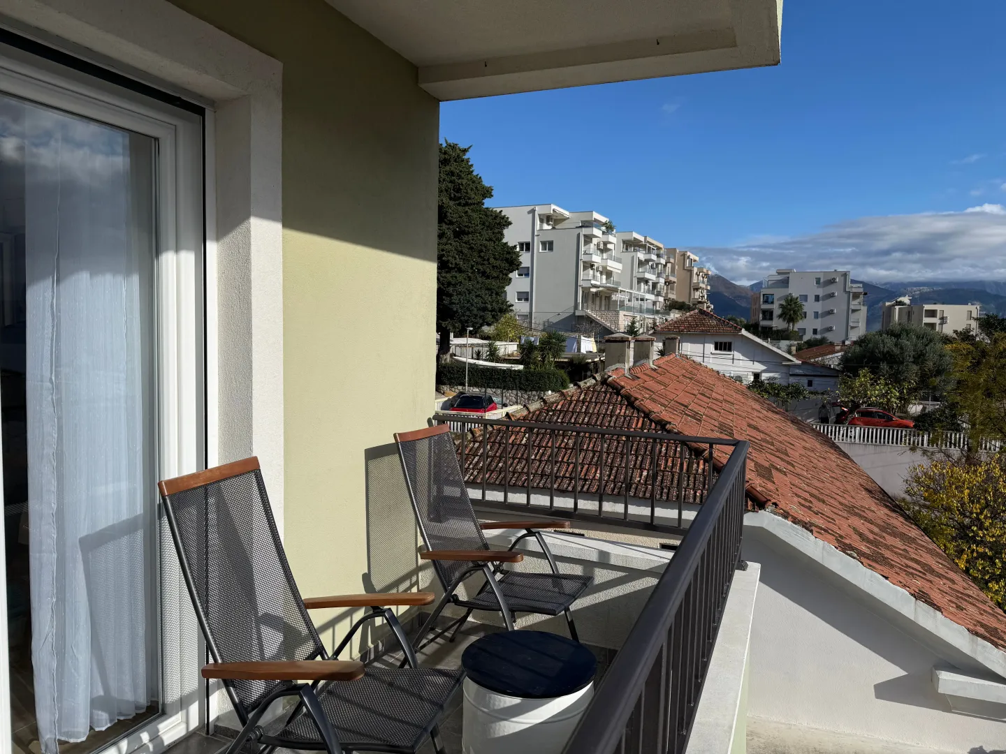Namješten balkon sa garniturom za sjedenje i pogledom na naselje.