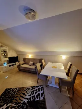 Bright living room with a dining table under a sloped ceiling. - image 6