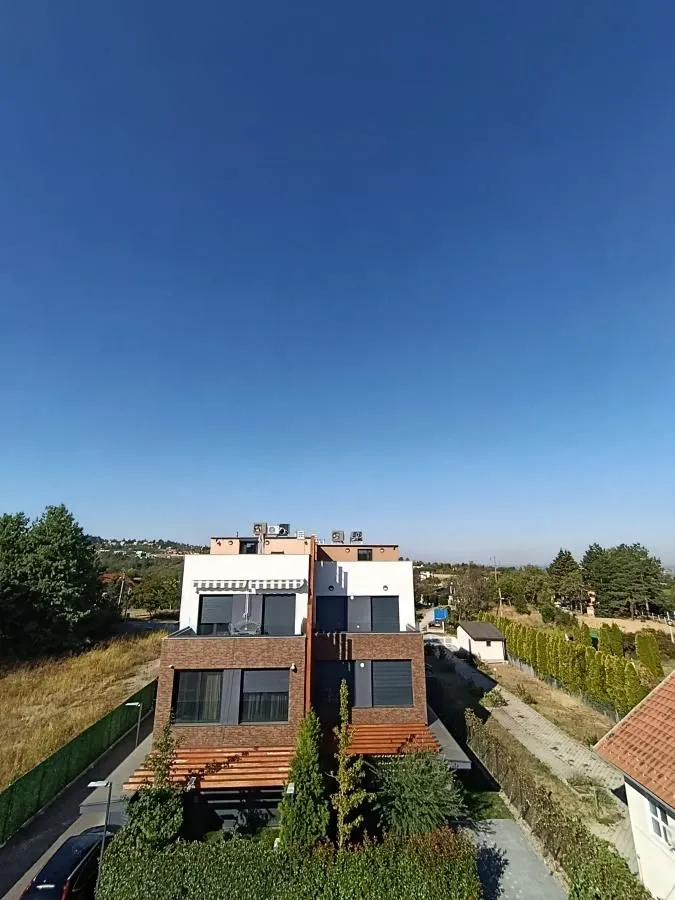 View of the exterior of a modern residential building with a yard.