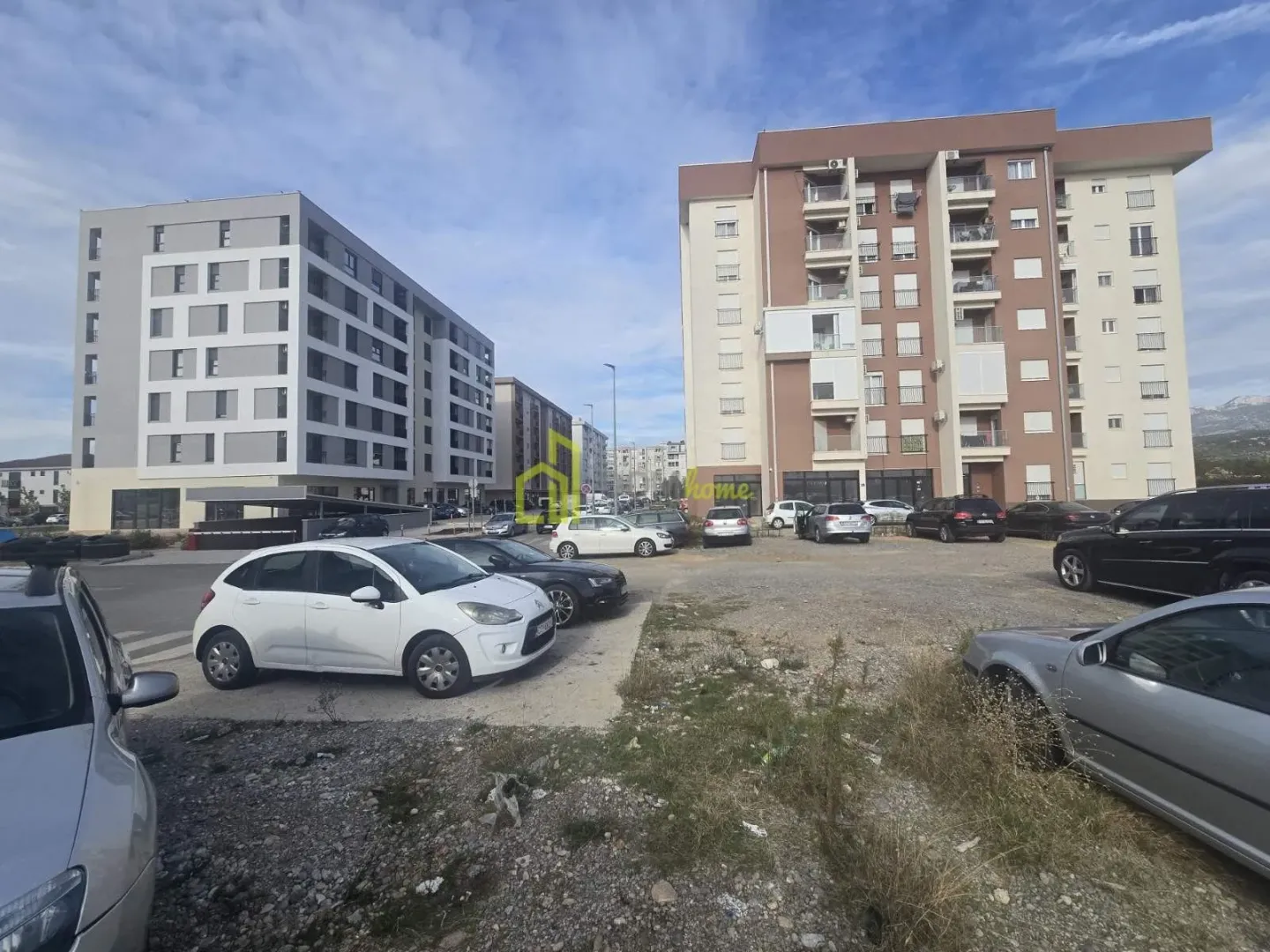 Pogled na parking prostor ispred stambenih zgrada.