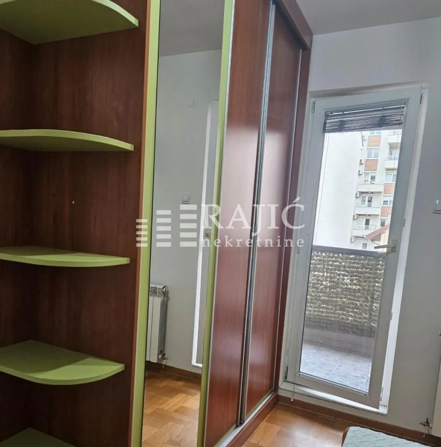Bedroom with a large wardrobe and balcony access.