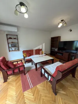 Living room with seating furniture, coffee table, and television. - image 2