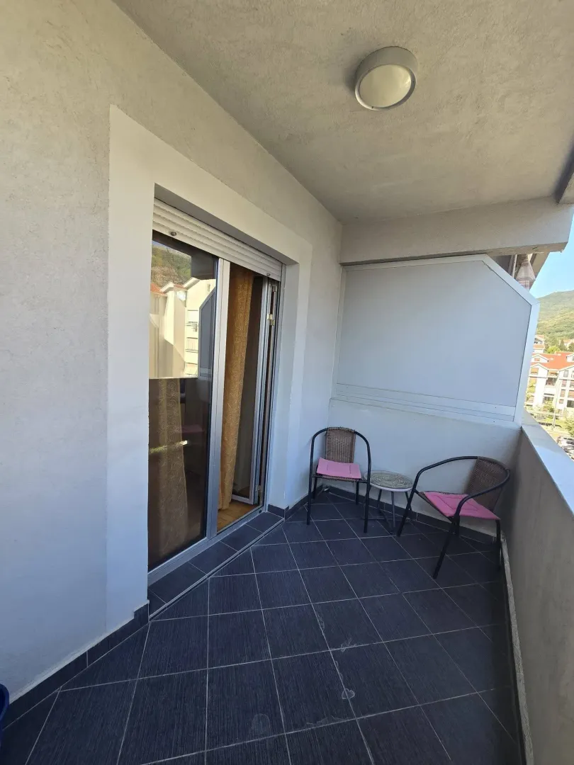 Natkriveni balkon sa garniturom za sjedenje i izlazom iz stana.