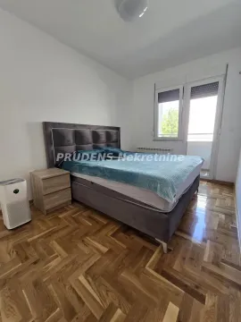 Nameštena spavaća soba sa bračnim krevetom, noćnim stočićem i parketom na podu. - image 12