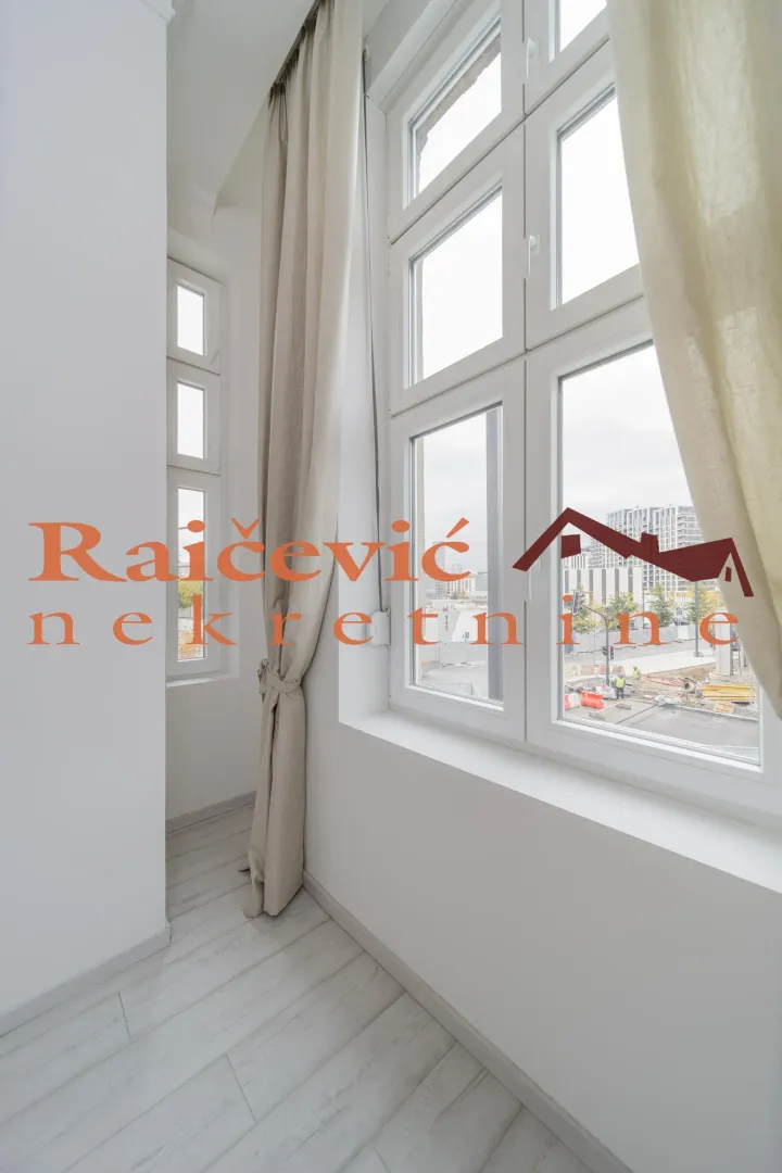 Empty bright room with large windows and curtains.