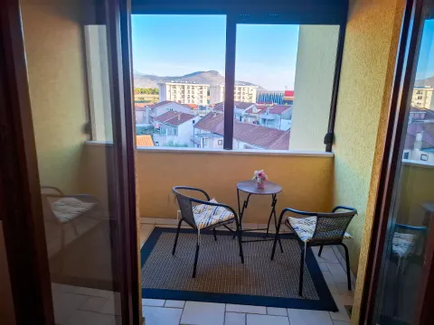 Enclosed balcony space with a small table, chairs, and a city view. - image 5
