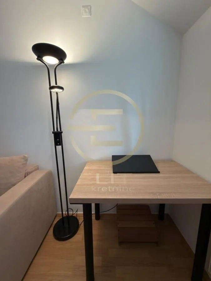 Detalj enterijera sa radnim stolom i lampom.