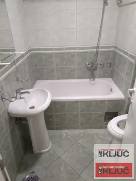 Manje kupatilo sa kadom, umivaonikom i toaletom obloženo keramičkim pločicama. - image 9