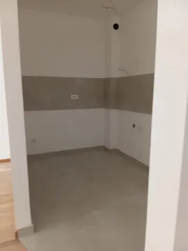 Prazna neopremljena prostorija sa pločicama na podu i zidovima u završnoj obradi. - image 3