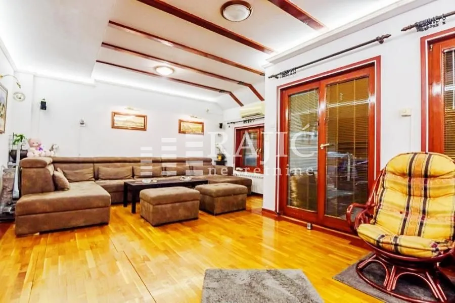 Spacious living room with sofa set and wooden floor.