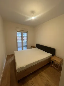 Simple bedroom with a double bed and balcony access. - image 3