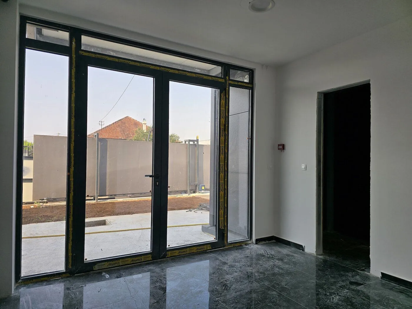 Empty room with large glass doors and an exit to the yard.