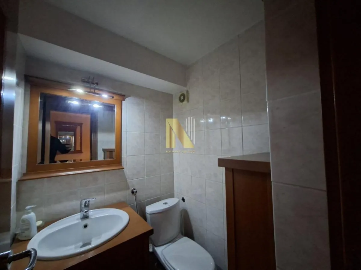 Bathroom equipped with a sink, mirror, and toilet bowl.