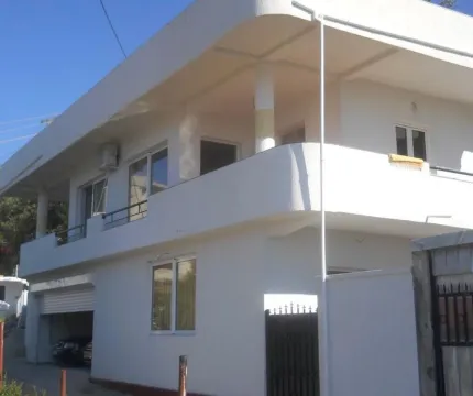 Exterior view of a two-story white house with balconies and a garage. - image 6
