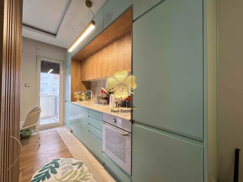 Modern kitchen with green cabinets and wooden details. - image 4